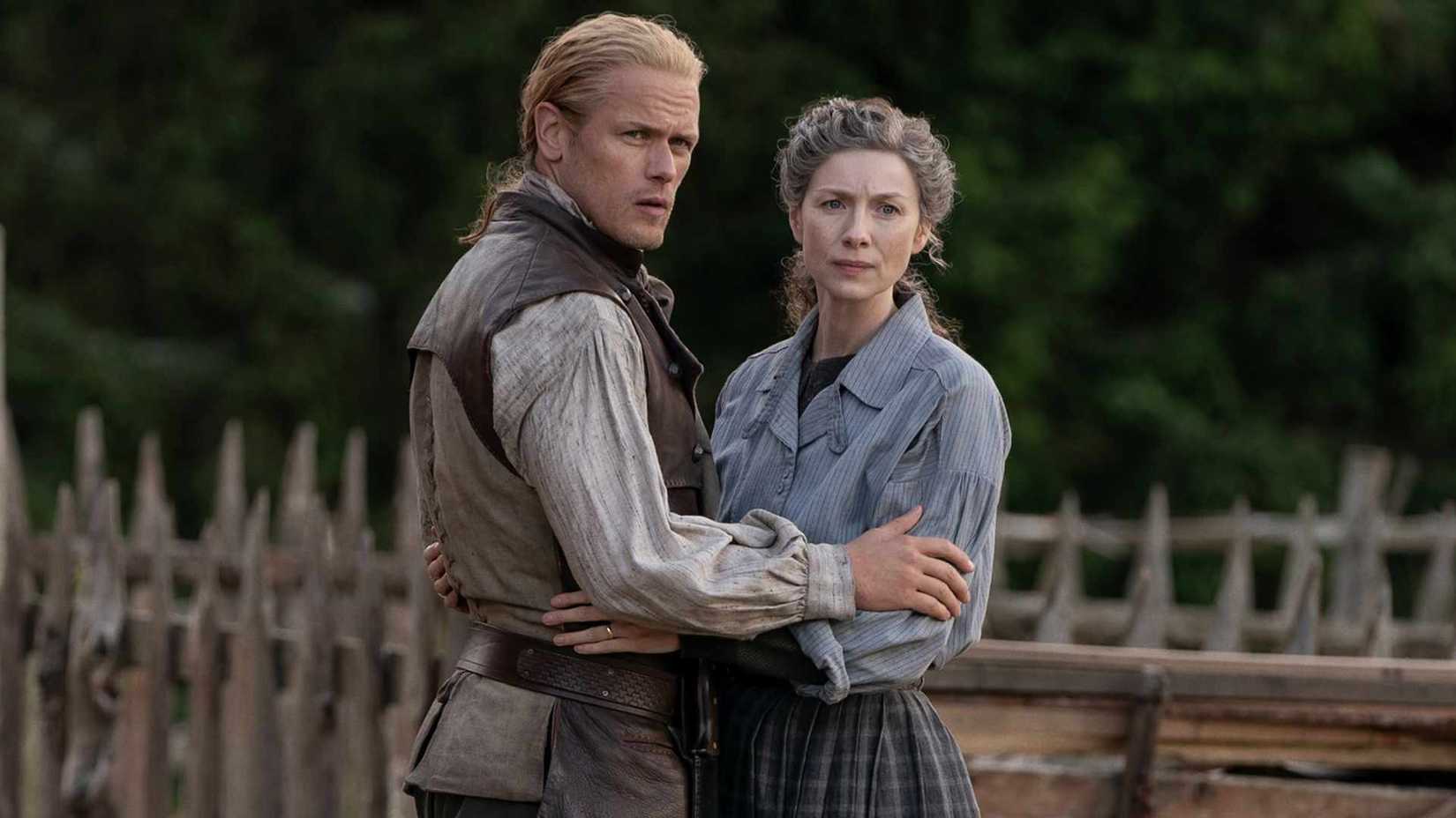 The Truth About Captain Cunningham Revealed 4 Jamie and Claire holding each other while looking stern in Outlander season 8