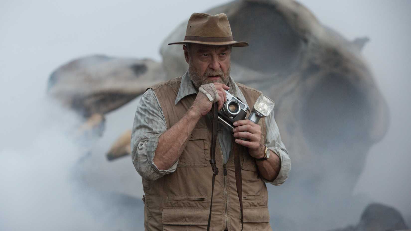 John Goodman como Bill Randa com uma câmera em Kong Skull Island