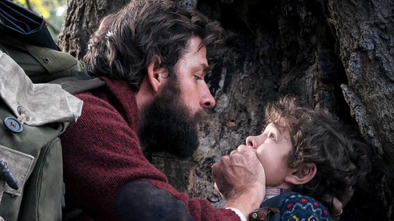 John Krasinski como Lee cobrindo a boca de Marcus (Noah Jupe) em A Quiet Place