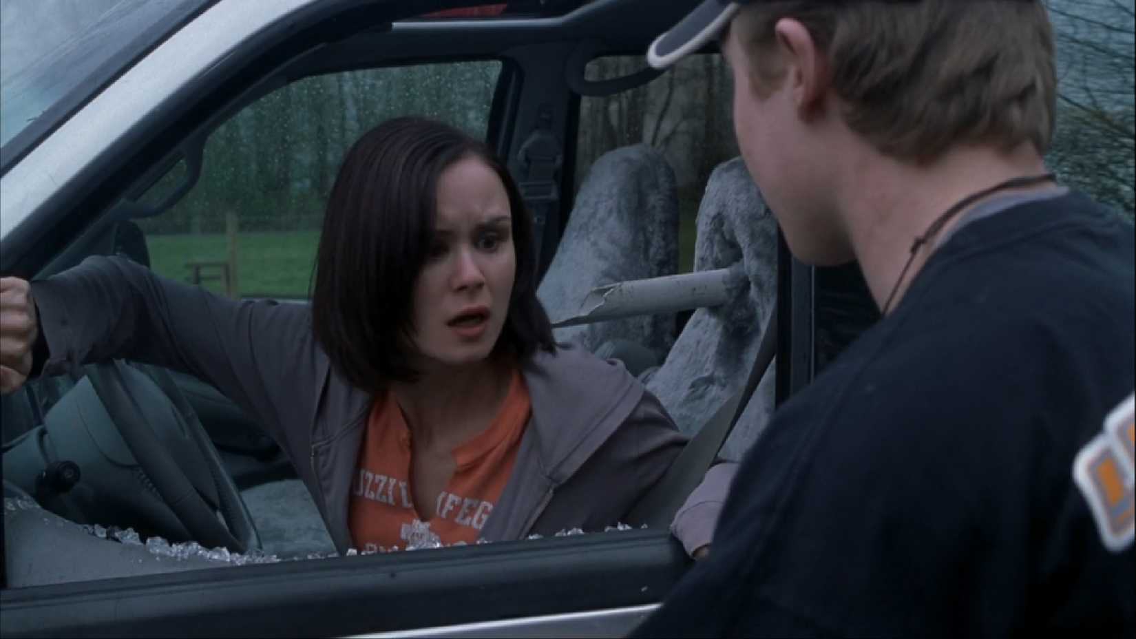 Kat Jennings de Premonição 2 no banco da frente de seu carro, com um cano de PVC quebrado ao lado dela