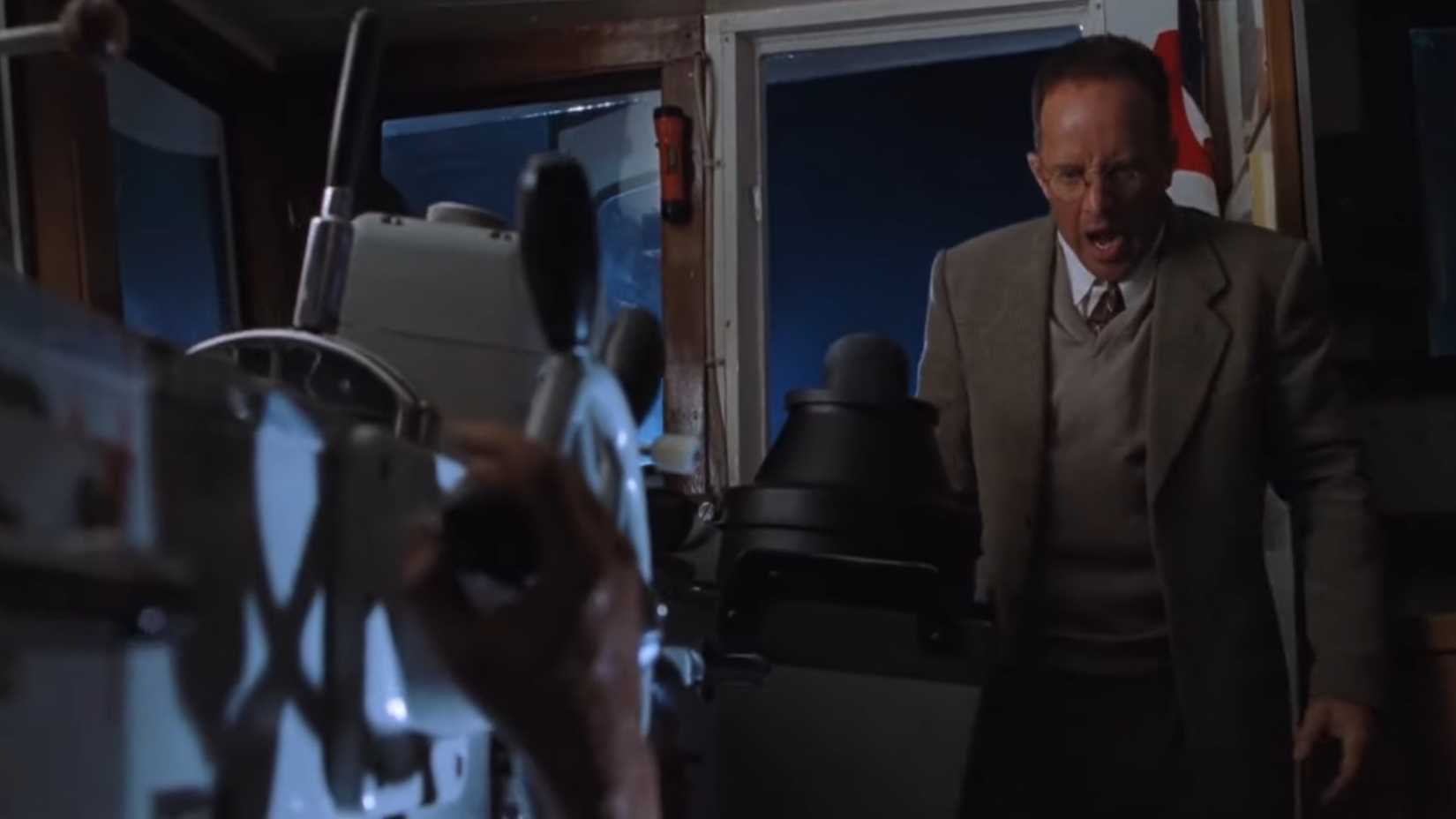 Ludlow chocado olhando para uma mão decepada no barco em O Mundo Perdido: Jurassic Park