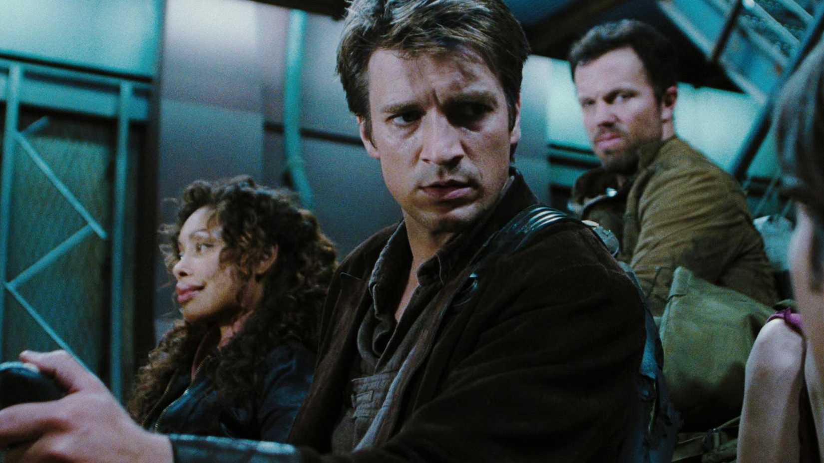 Mal (Nathan Fillion) ao lado de Zoe (Gina Torres) e Jayne (Adam Baldwin) prestes a deixar a nave em Serenity.