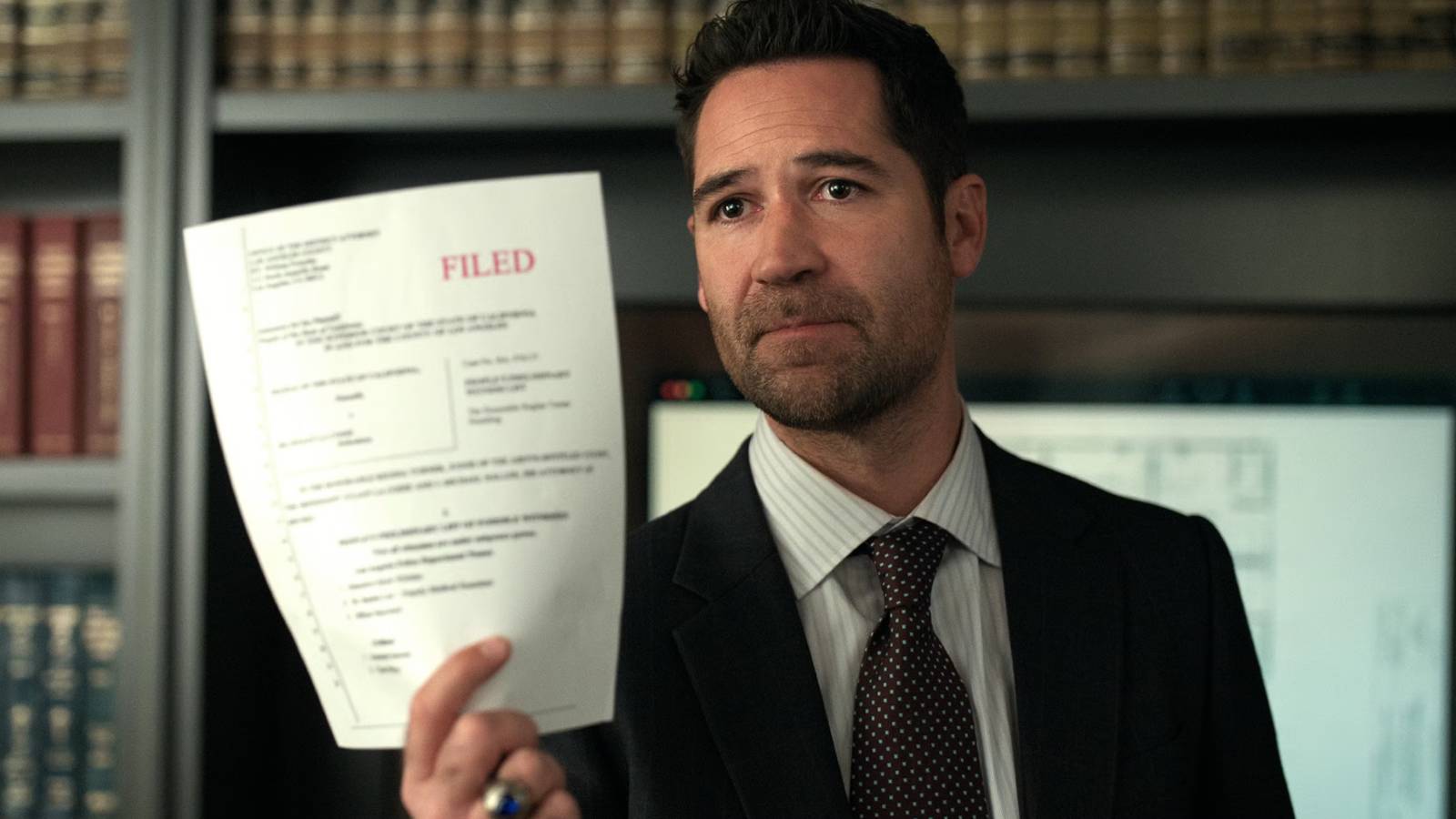 Mickey holding up a document in The Lincoln Lawyer