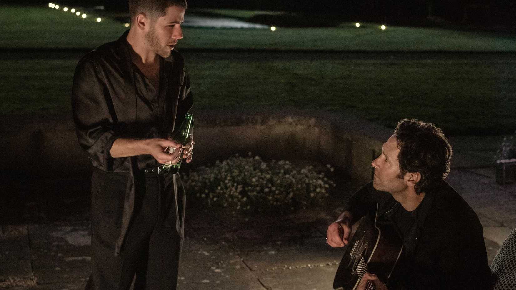 Nick Jonas and Paul Rudd playing guitars together in Power Ballad
