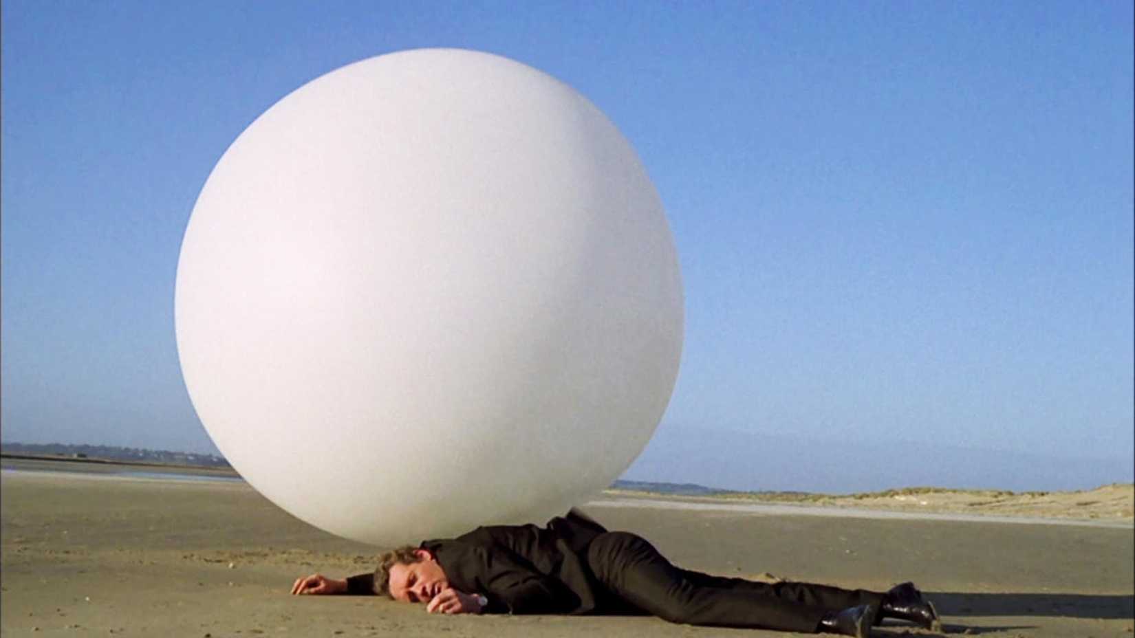 Number Six getting squashed by a white ball in The Prisoner