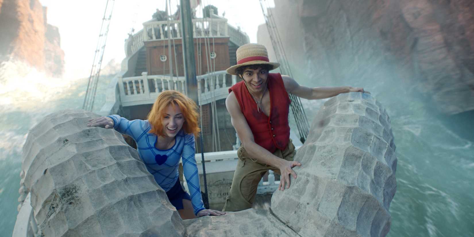 Monkey D. Luffy e Nami sorrindo em seu navio na série live-action de One Piece.
