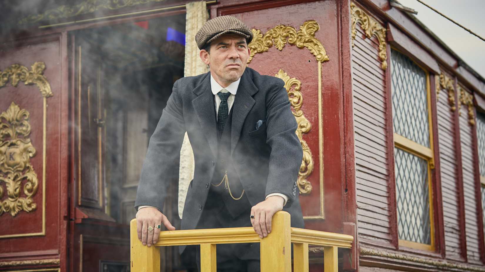 Peaky Blinders: The Immortal Man Cast Guide 5 Packy Lee as Johnny Dogs standing outside a carriage and looking into the distance in Peaky Blinders