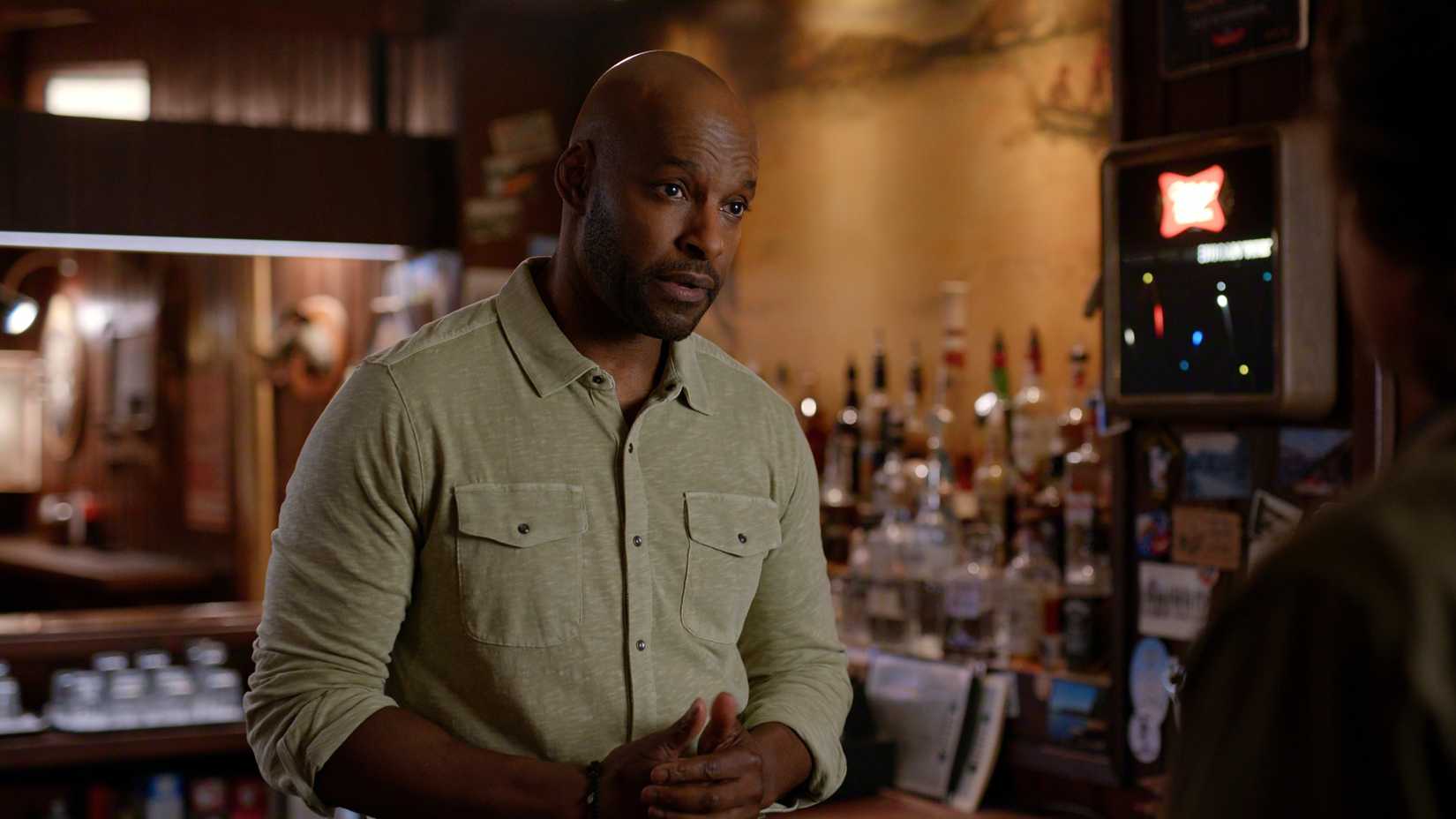 Preacher stands behind the bar while talking to Jack in Virgin River season 7, episode 8