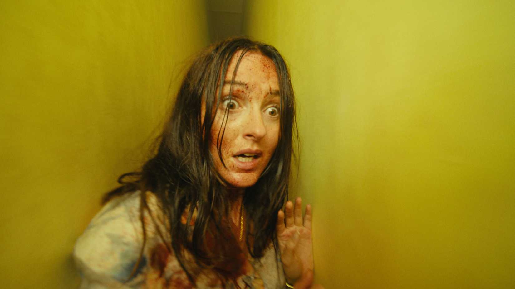 Renate Reinsve correndo por um corredor estreito em Backrooms