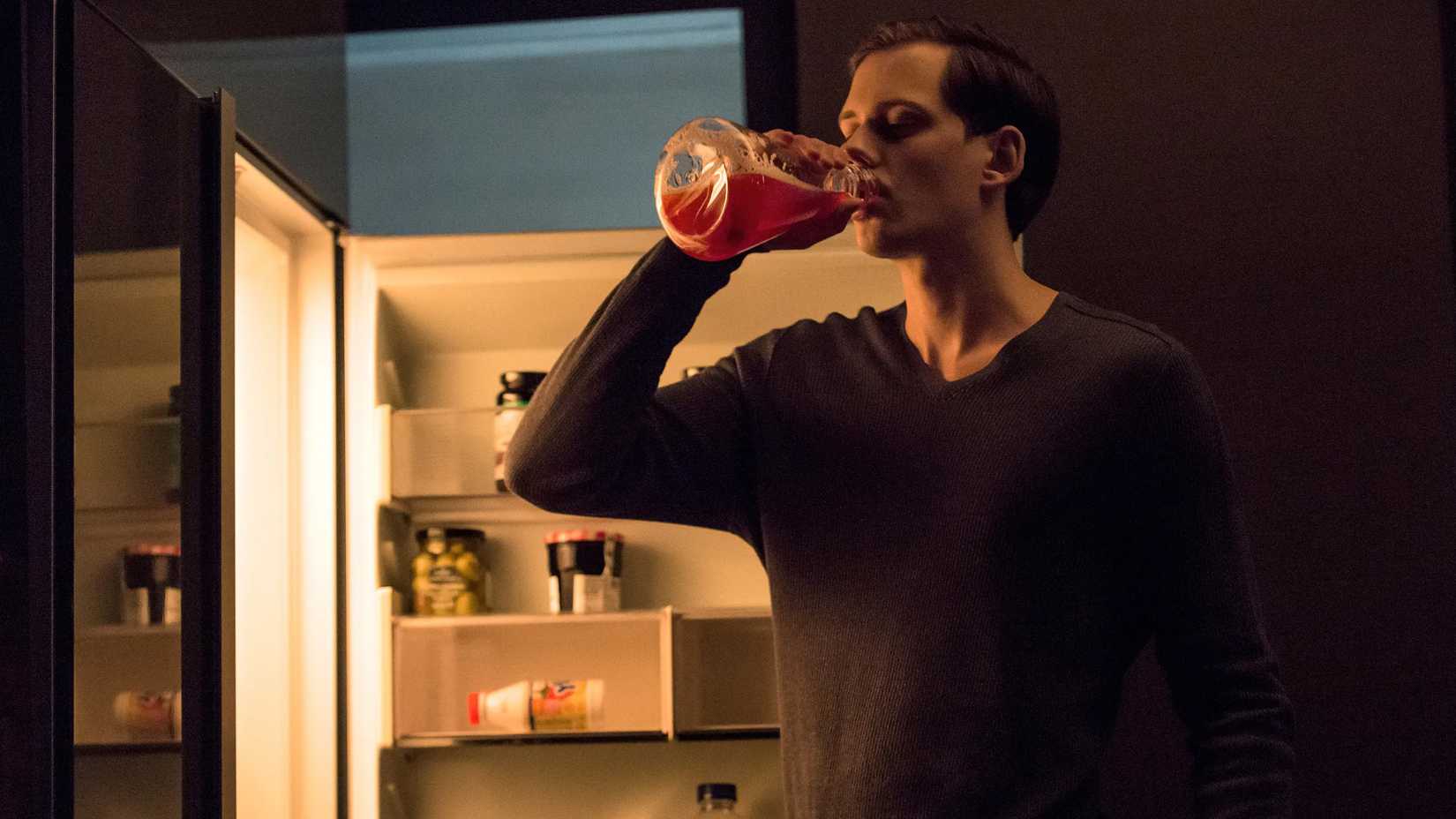 Roman Godfrey bebendo sangue de um frasco na série Hemlock Grove.