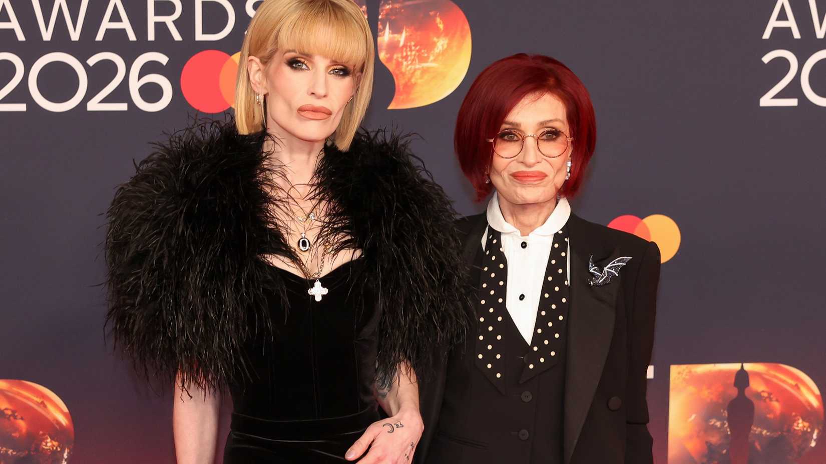 Sharon and Kelly Osbourne posing together on the red carpet at the 2026 BRIT Awards.
