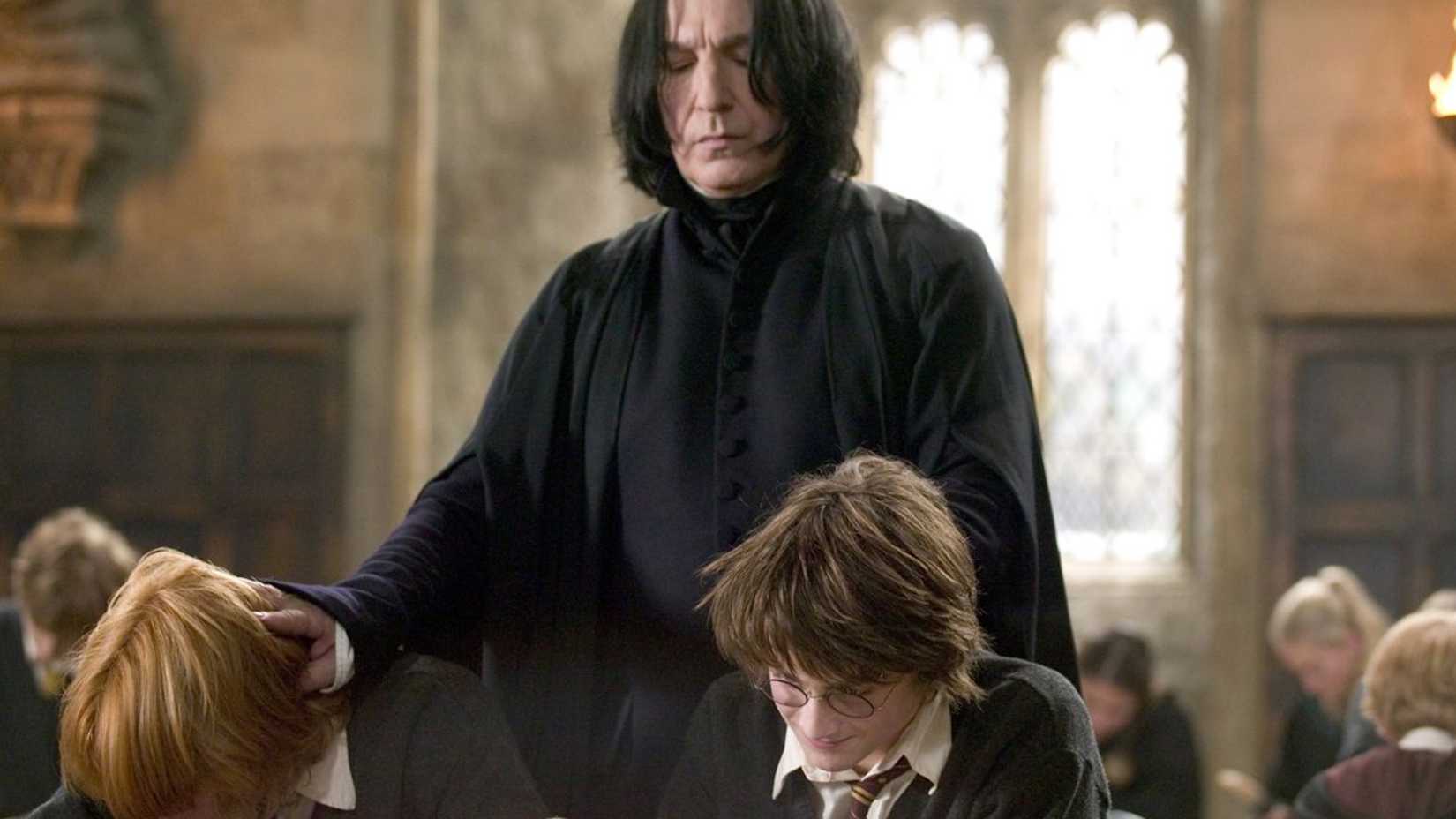 10 Ways Rewatching All 8 Harry Potter Movies In Order Changes How You Look At The Films 3 Snape (Alan Rickman) standing behind Harry Potter (Daniel Radcliffe) and Ron (Rupert Grint) in class