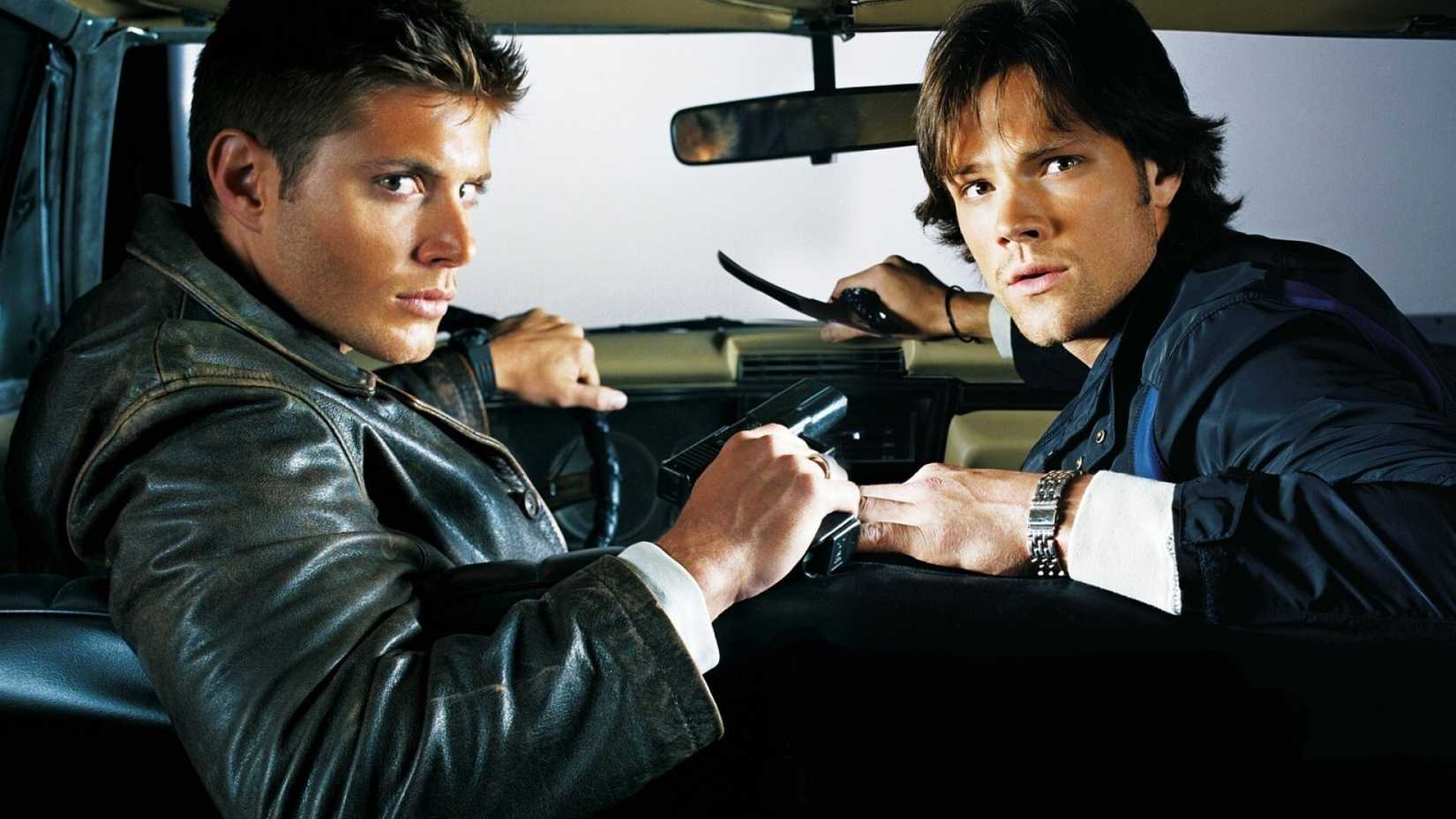 Supernatural promo photo featuring Dean and Sam leaning over the front seat of the Impala.