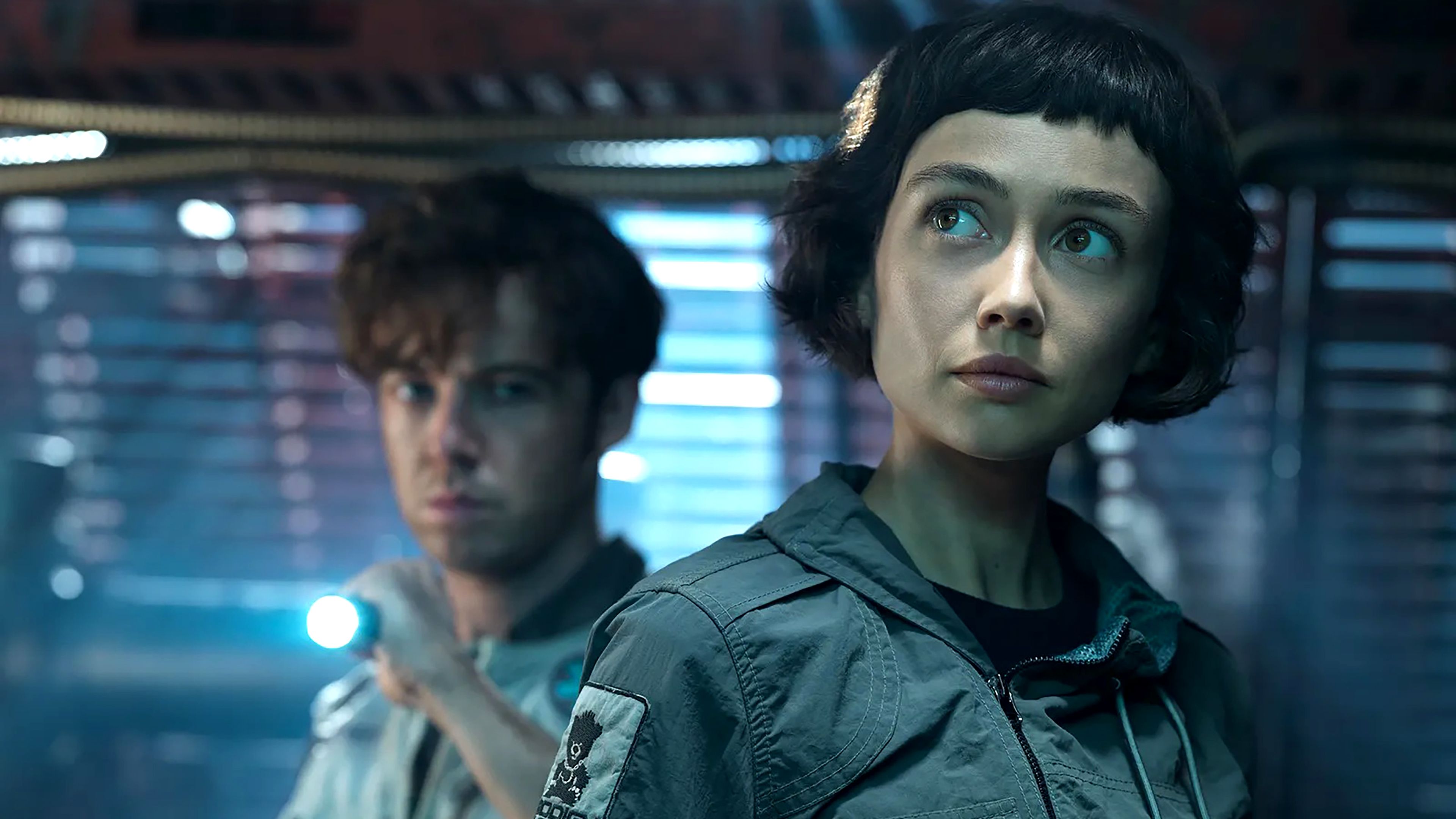 Sydney Chandler's Wendy looking intrigued with Alex Lawther's Joe pointing a flashlight in the background in Alien: Earth season 1