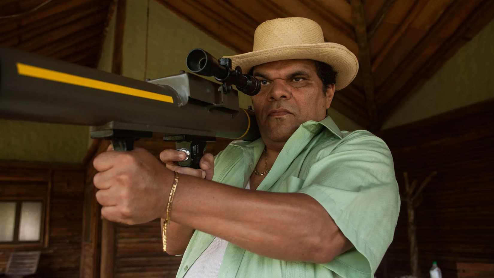 Luis Guzman pointing a gun in Narcos