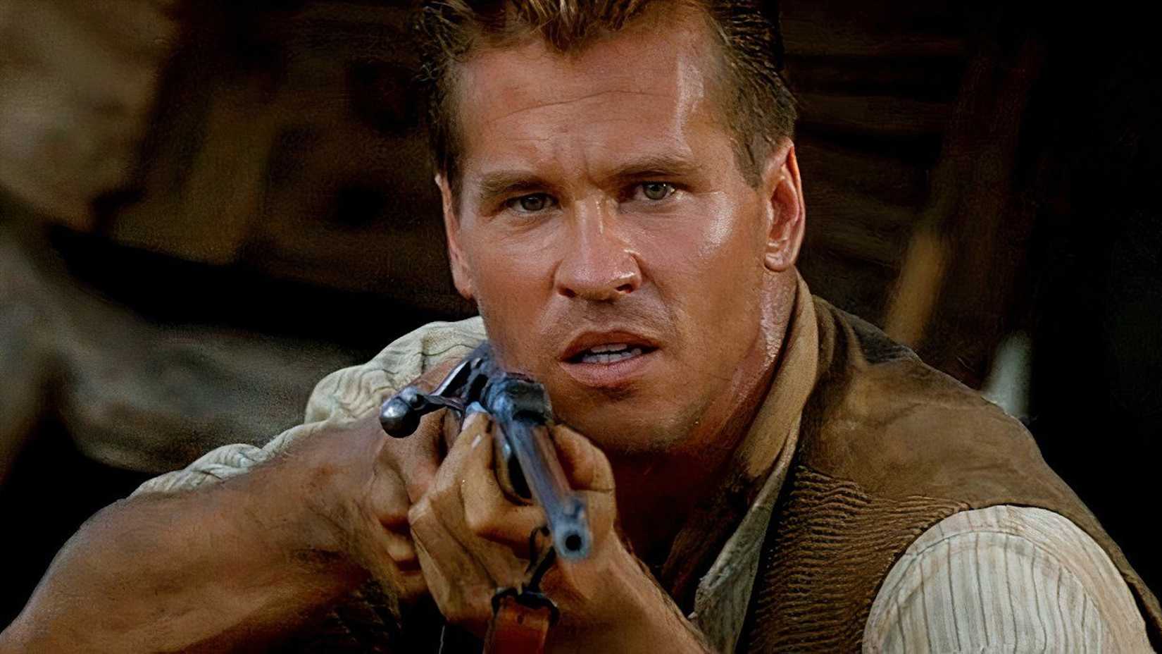 val kilmer as colonel patterson aiming his rifle at a lion in the ghost and the darkness
