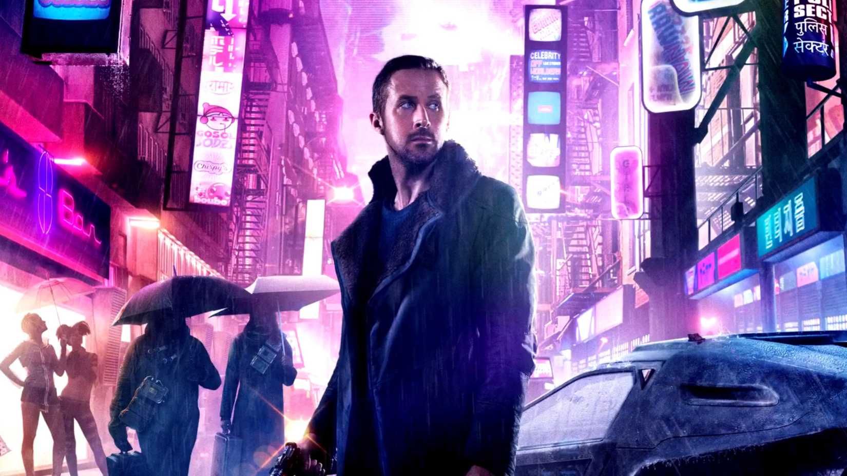 Ryan Gosling’s K standing in the background of a neon-soaked cyberpunk city in Blade Runner 2049