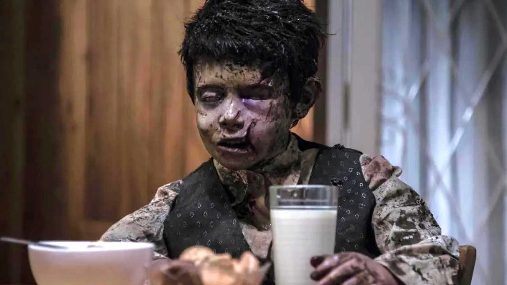 a young kid who looks worn out trying to hold his milk in terrified