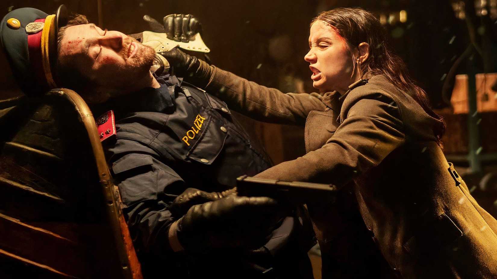 Ana De Armas como Eve lutando contra um homem com uniforme de policial em Ballerina