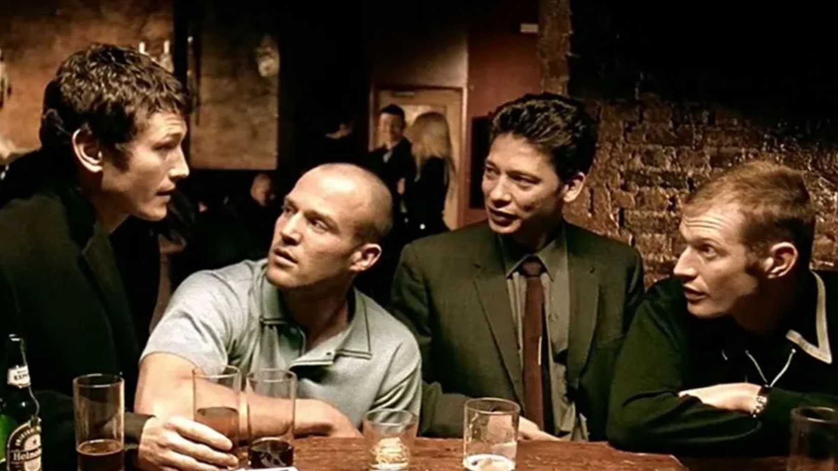 Bacon surrounded by his friends in a pub in lock stock and two smoking barrels