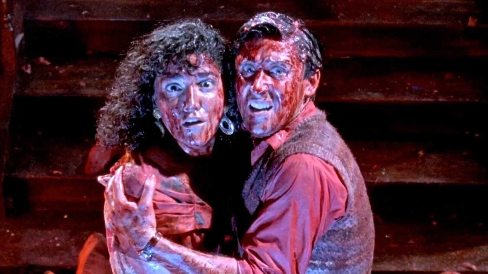 Two people crouching down covered in blood in Brain Dead