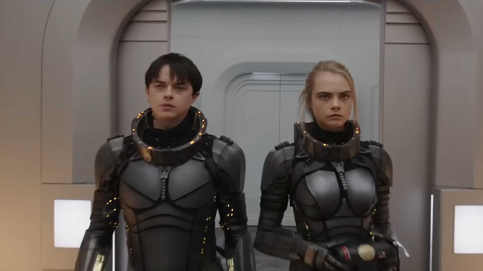 captain valerian and sergeant laureline standing side by side in a white hallway in valerian