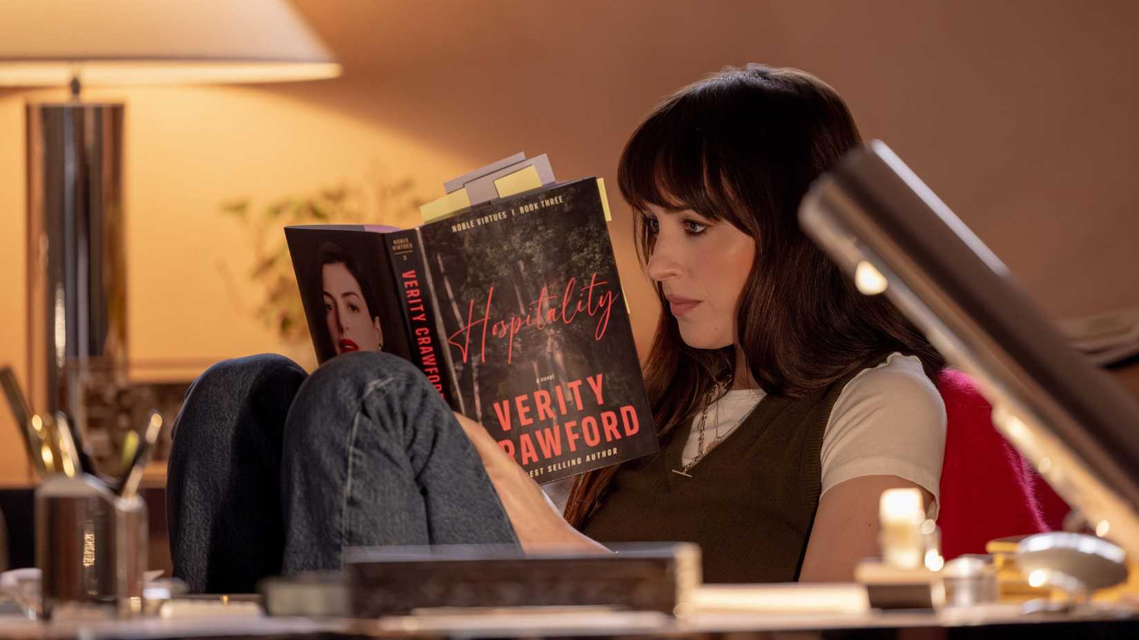 Dakota Johnson as Lowen reading a book in Verity