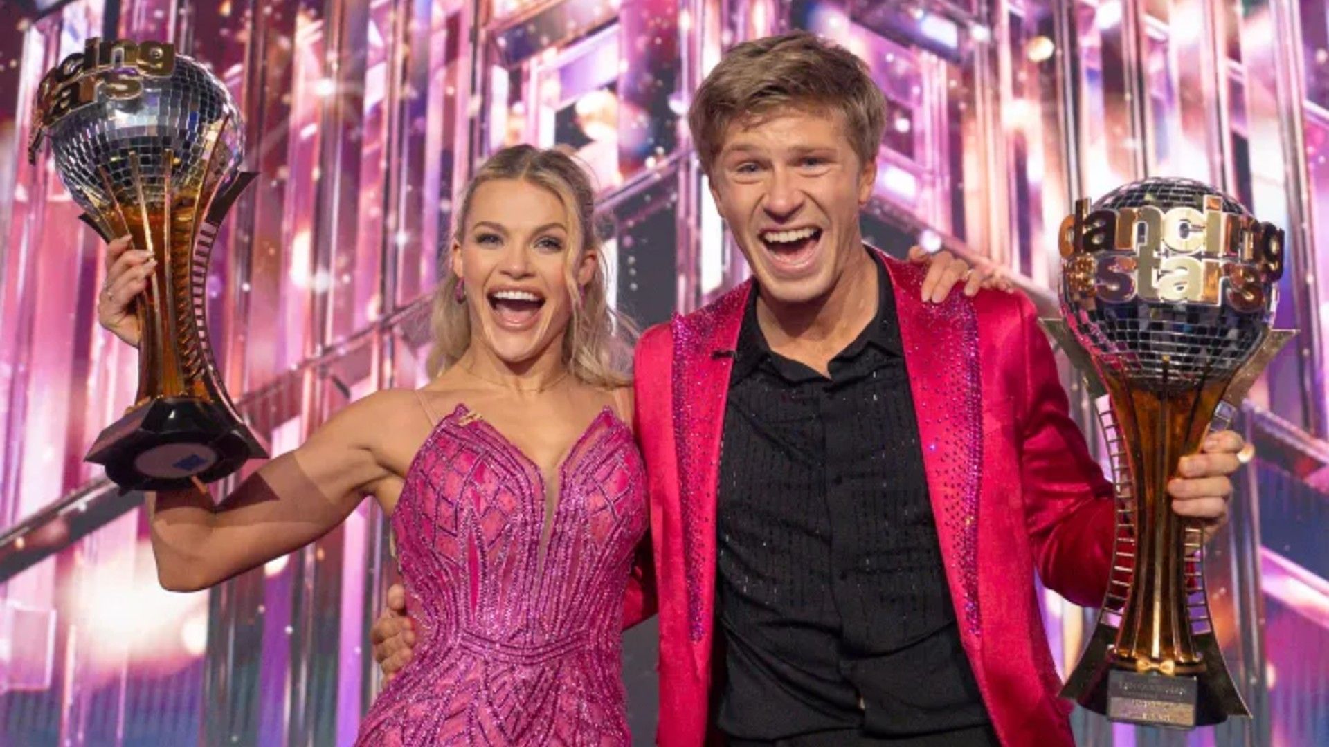 Dancing With The Stars Season 34 Winners Witney Carson and Robert Irwin Holding Mirrorball Trophies
