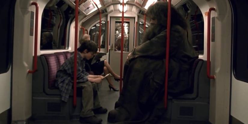 daniel radcliffe as harry and robbie coltrane as hagrid on the london underground in harry potter and the sorcerer s stone 2001