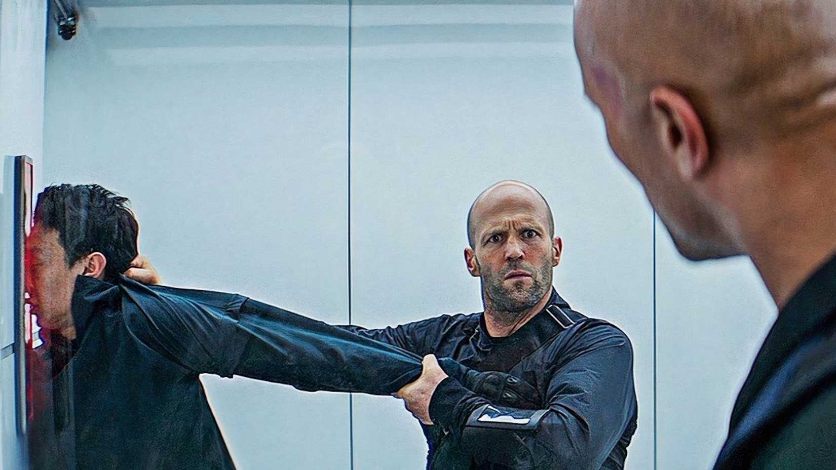 Deckard Shaw holding a nameless henchmans head against a scanner in Hobbs and Shaw