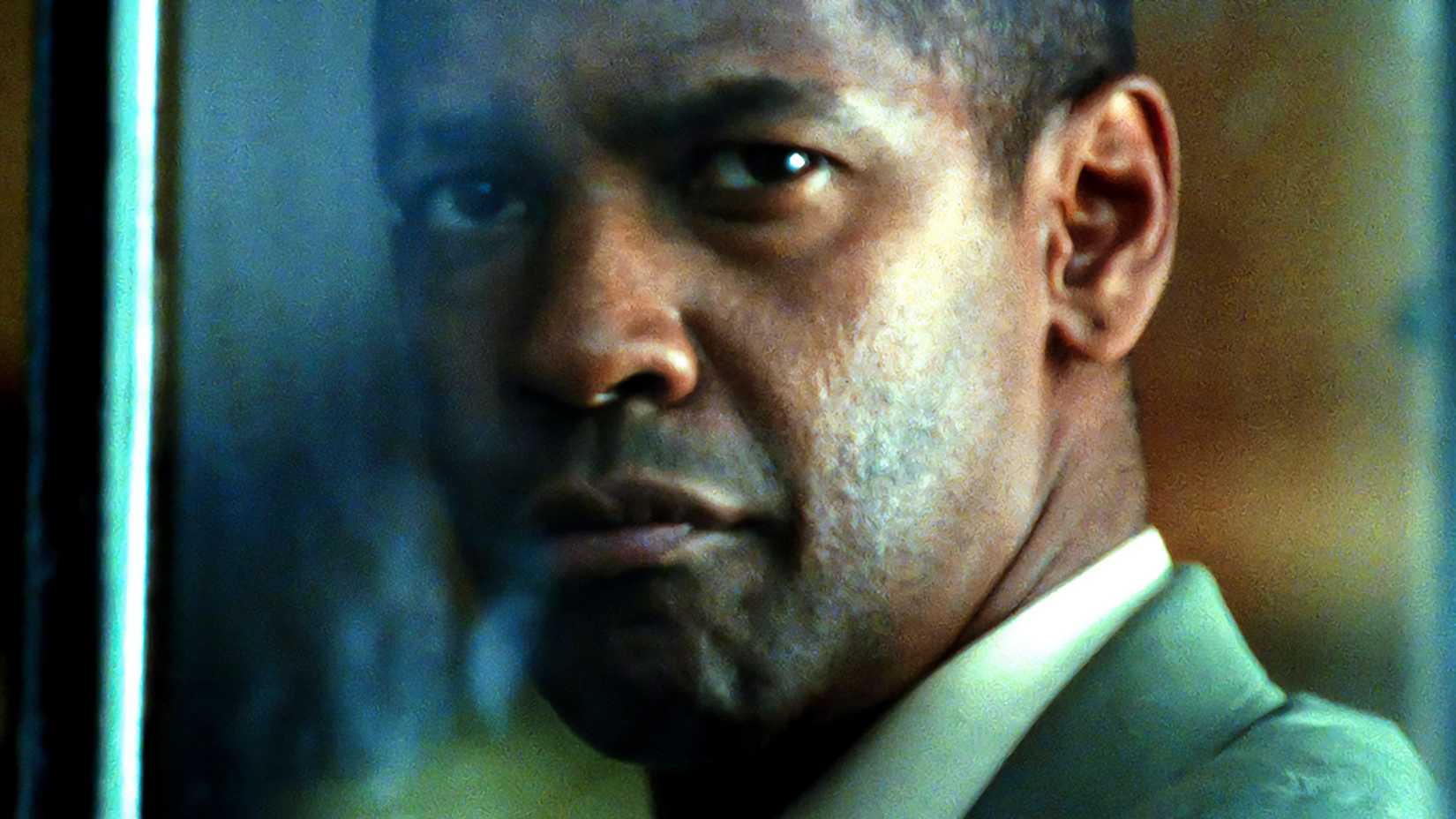 denzel washington s creasy looking intensely out of a window in man on fire