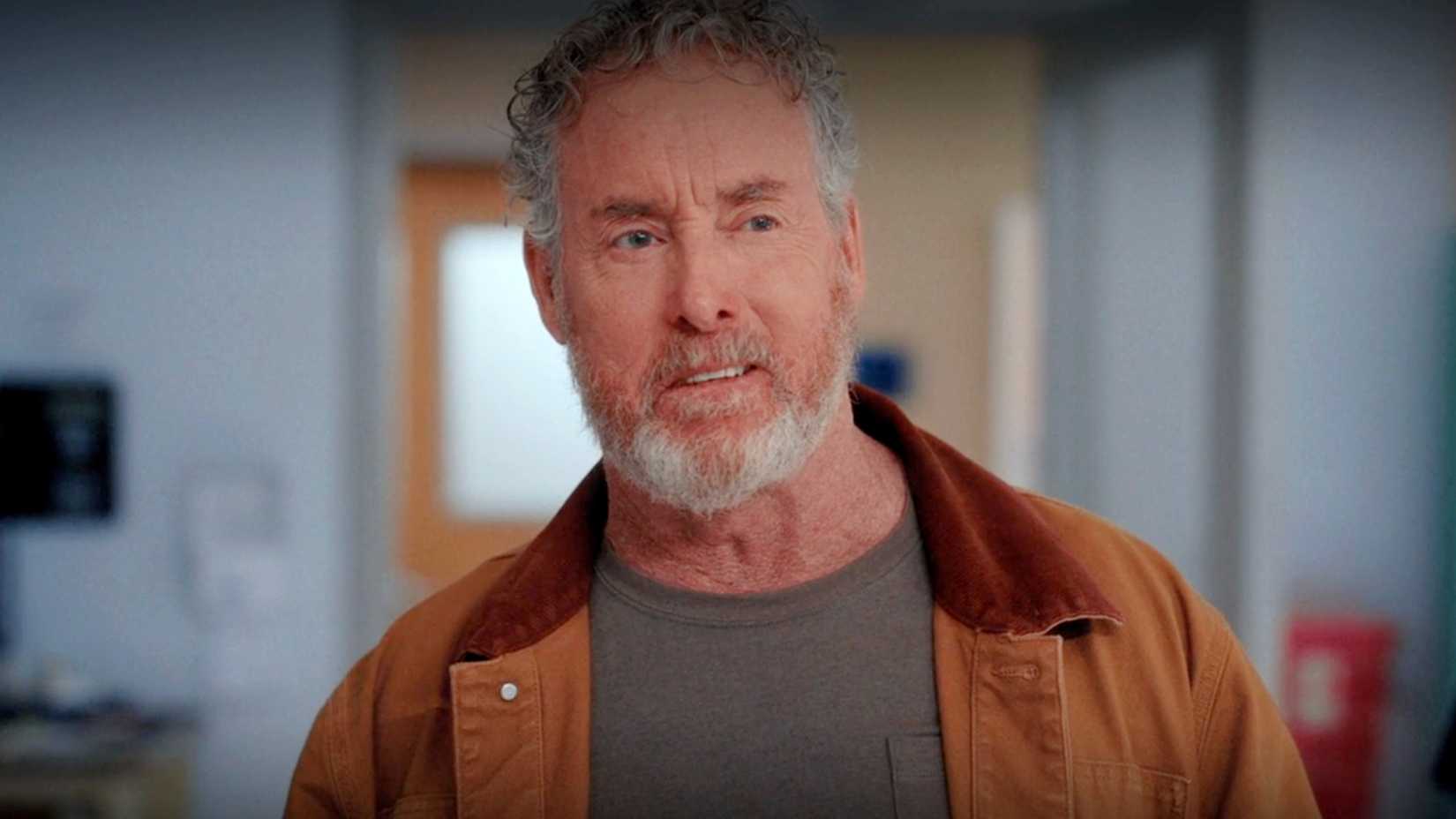 Dr. Cox sorrindo levemente na 10ª temporada de Scrubs