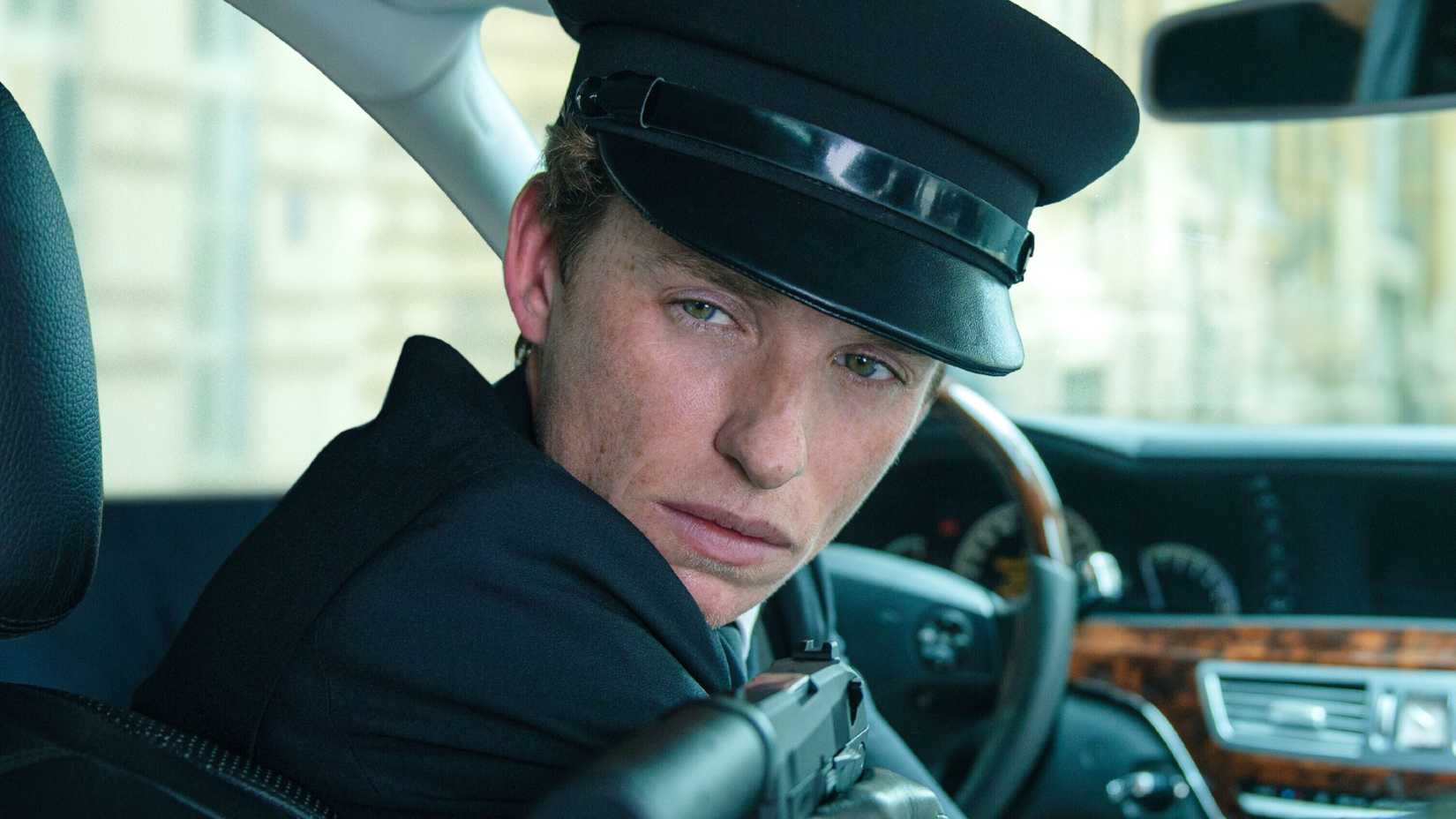 eddie redmayne aims his gun at someone in the day of the jackal season 1