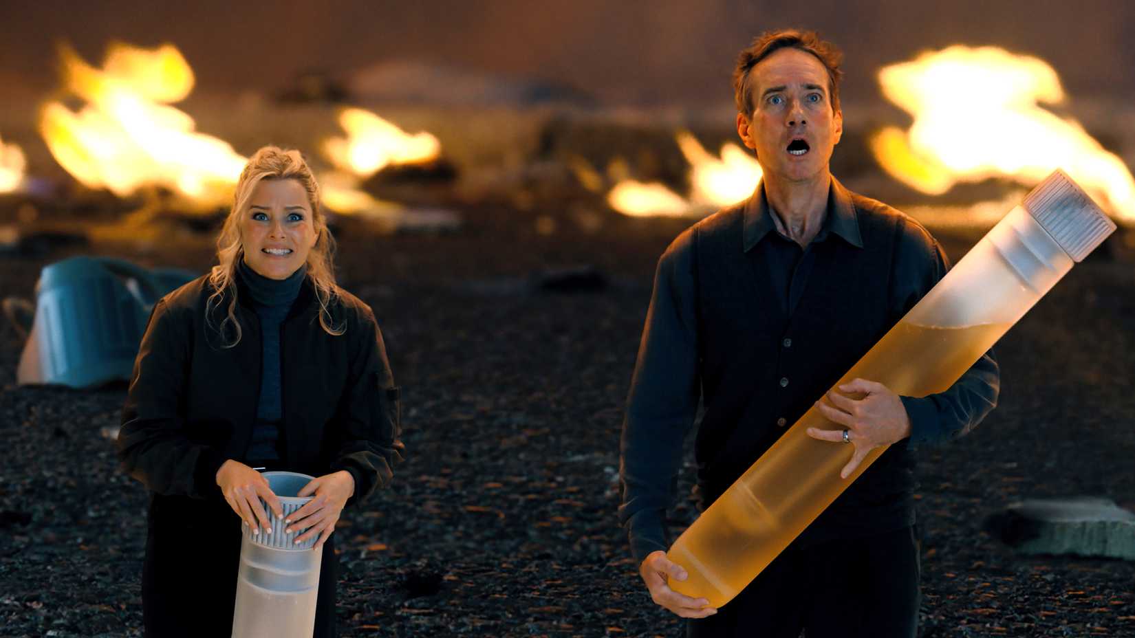 elizabeth banks lindy and matthew macfadyen s les looking shocked while holding giant test tubes in the miniature wife