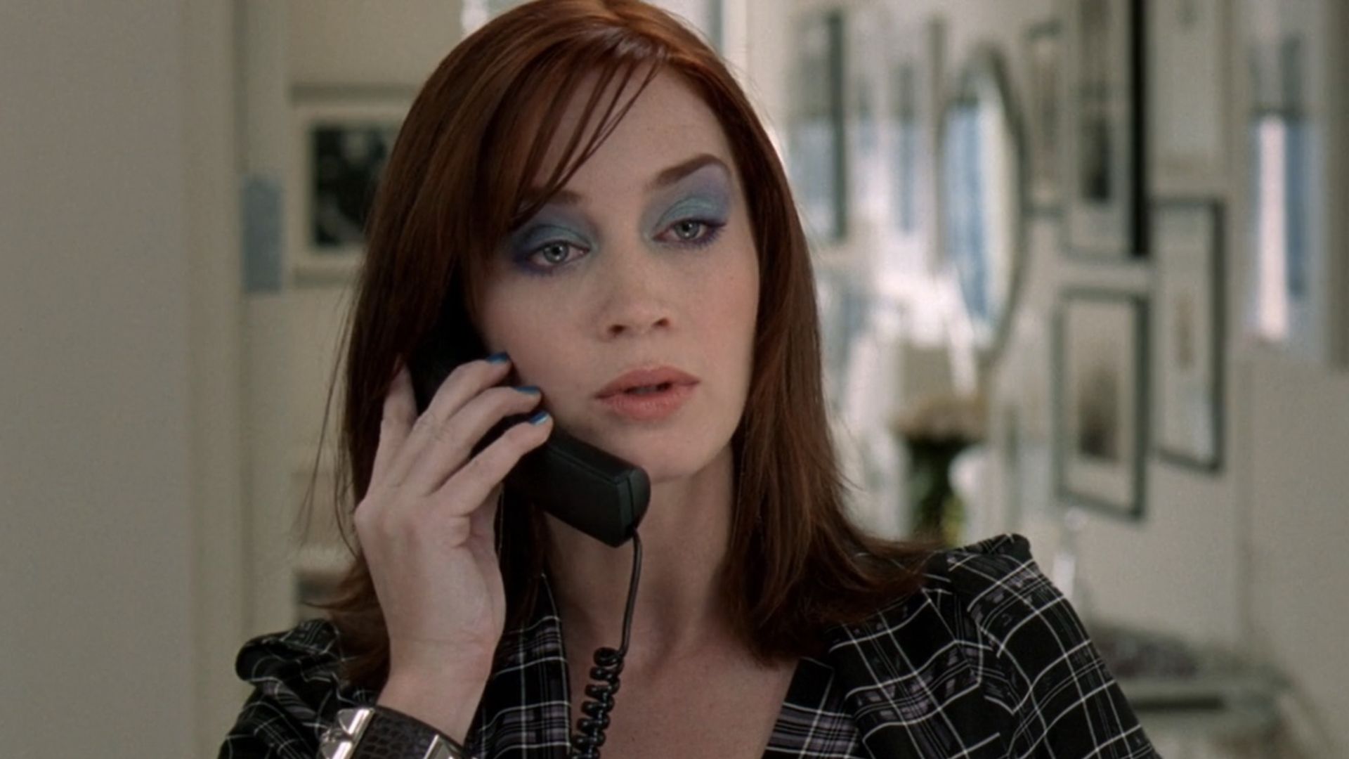 Emily atendendo o telefone em O Diabo Veste Prada