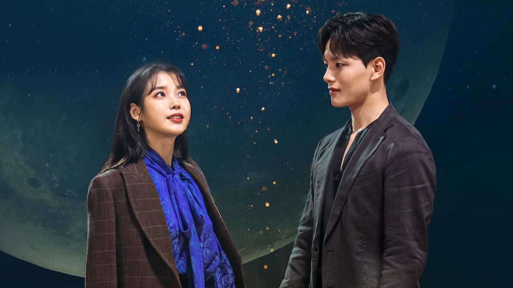 IU and Yeo Jin-goo standing in front of a night sky in Hotel del Luna.