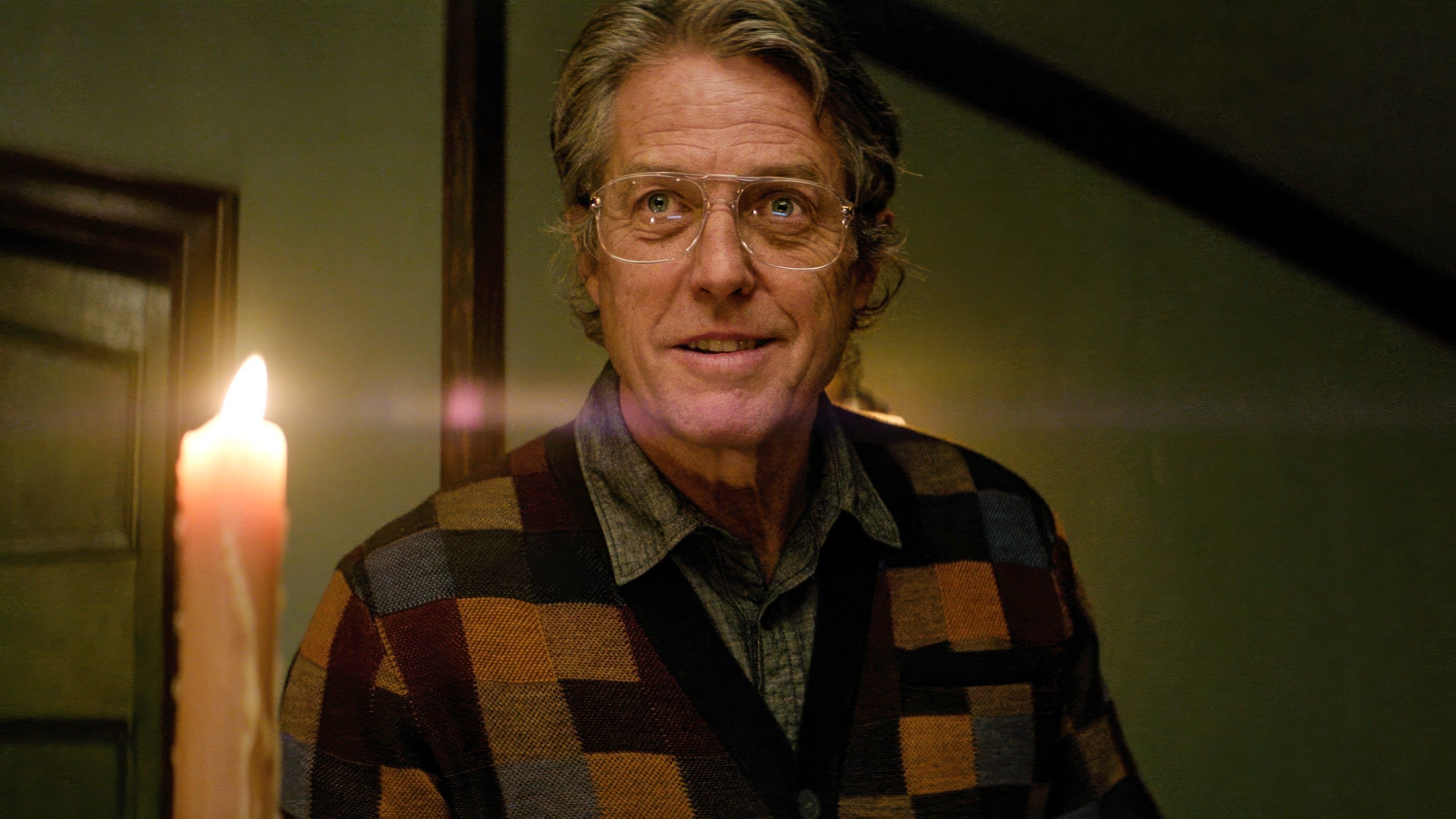 Hugh Grant Standing Near A Candle In Heretic Movie