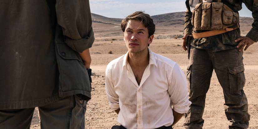 Jakob Oftebro ajoelhado no chão entre dois soldados em Agent Hamilton