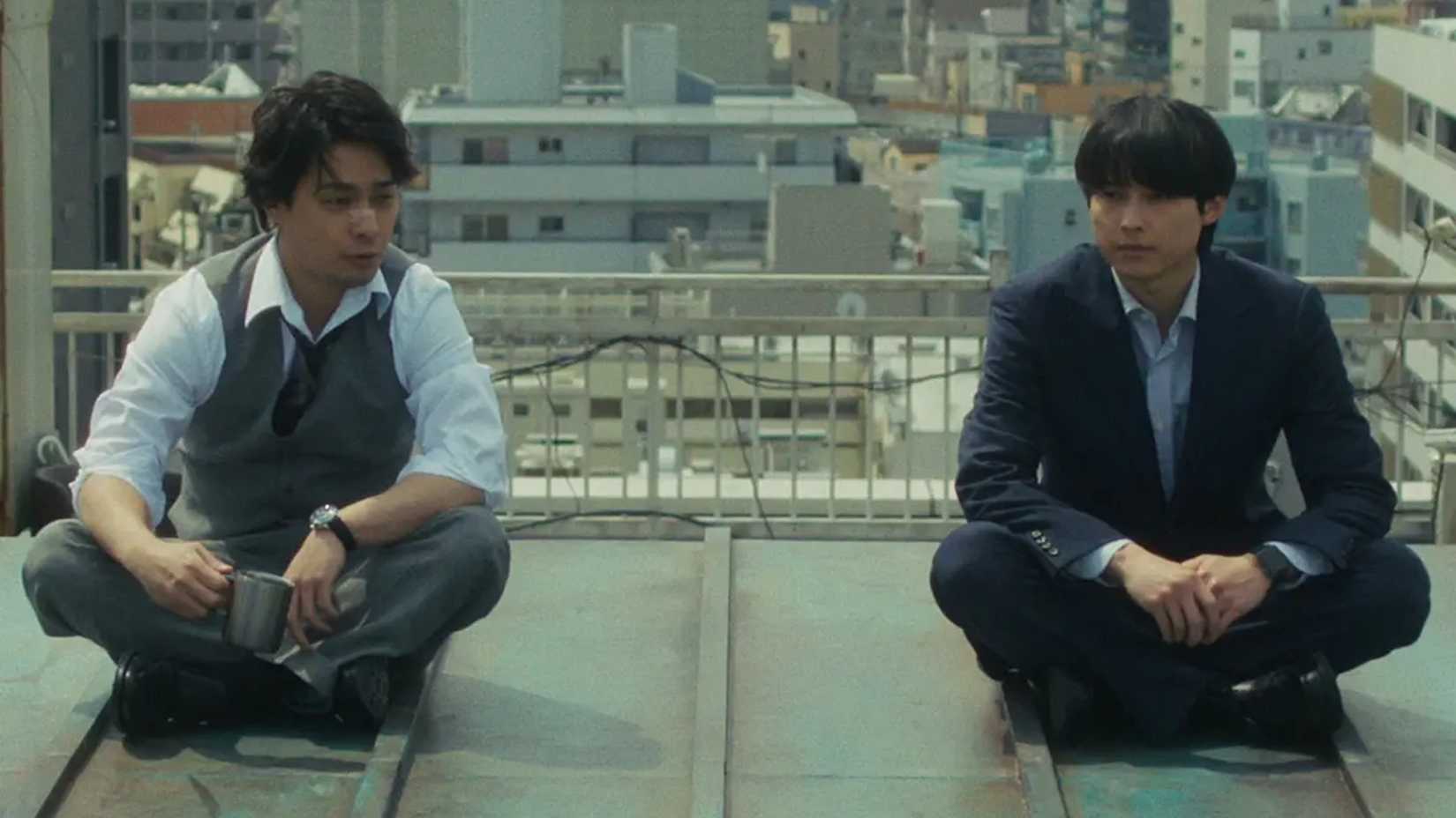 Kujo and Karasuma, from the Netflix series Sins of Kujo, sitting on the roof talking and drinking coffee
