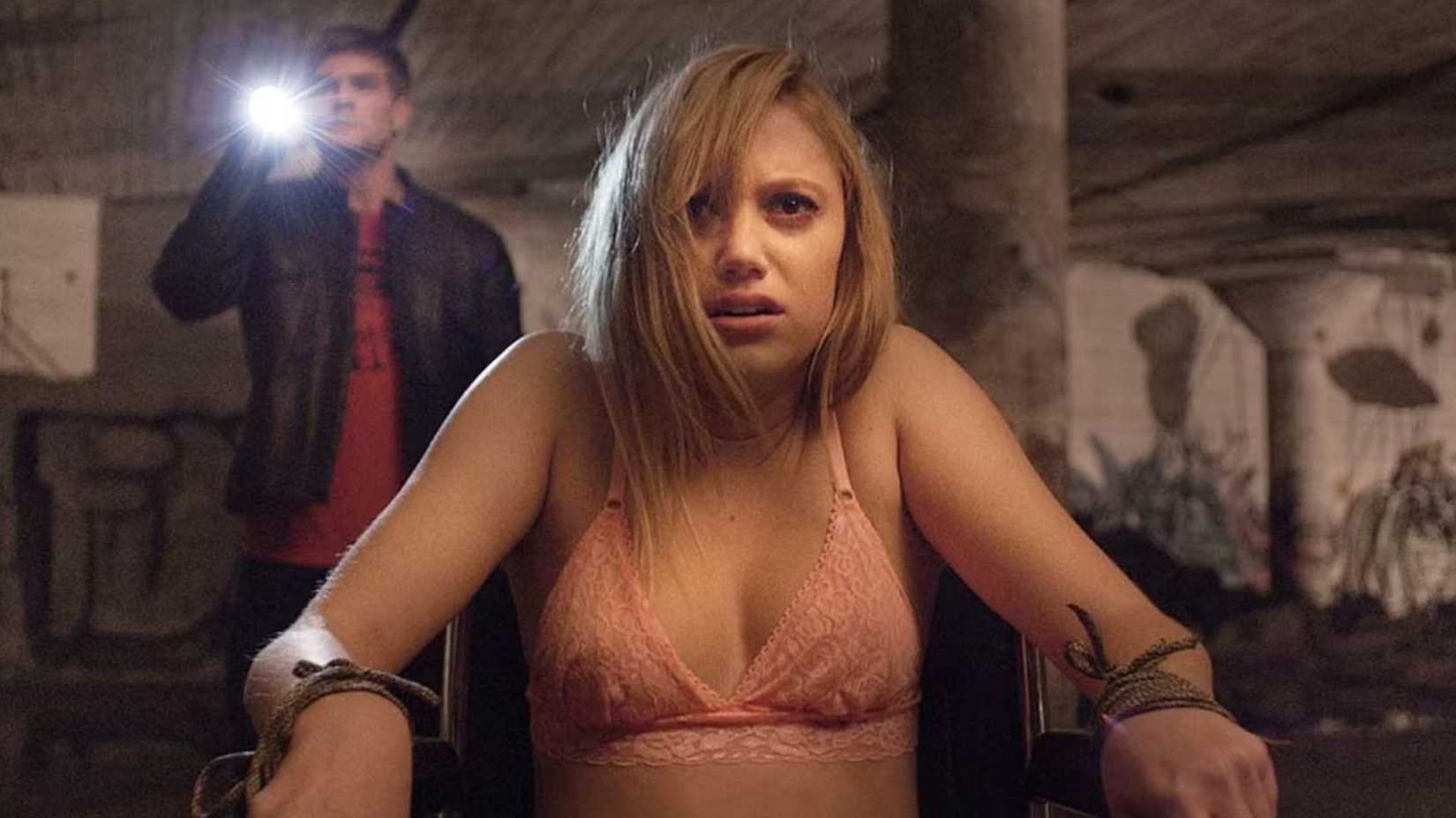 maika monroe as jay strapped to a chair in her undergarments in it follows