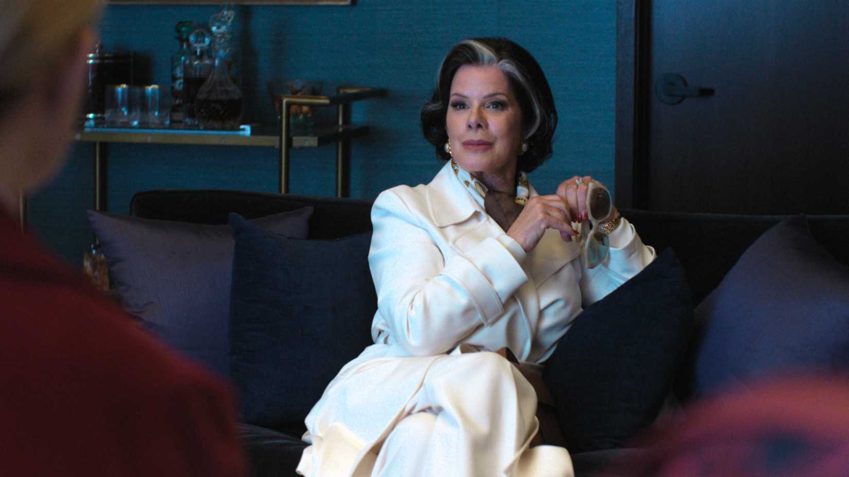 Mãe de Mark sentada no sofá em Margo's Got Money Troubles.