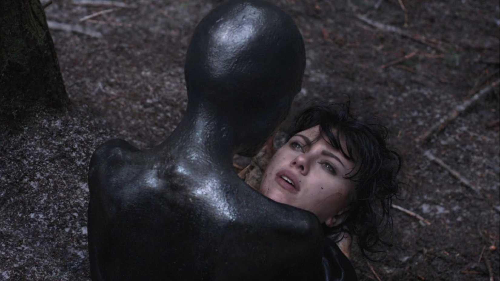 A black alien from behind holding Scarlett Johansson's face in Under the Skin
