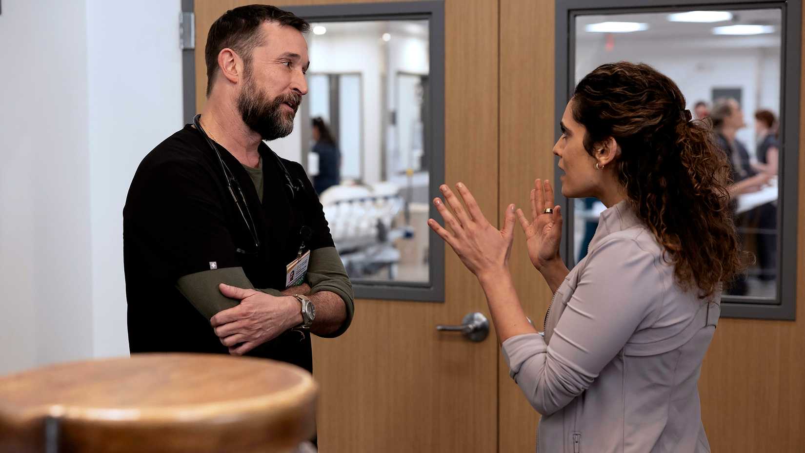 noah wyle s dr robby and sepideh moafi s dr al hashimi arguing in the hospital stairwell in the pitt season 2 vertical