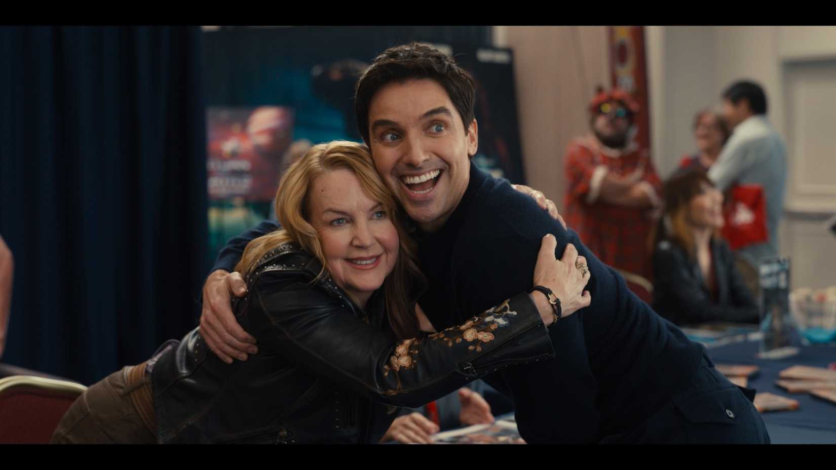 Renee O'Connor hugging Paul W. Downs in Hacks season 5, episode 2