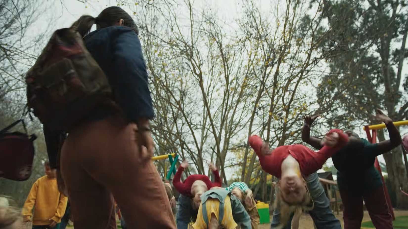 Xochitl Gomez como Sasha em Hive, cercada por crianças em posições incomuns.