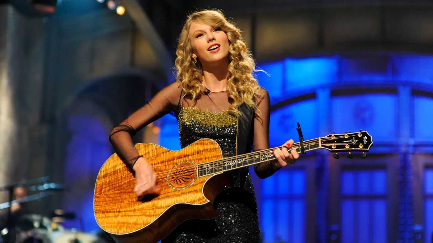 Taylor Swift plays guitar during SNL monologue