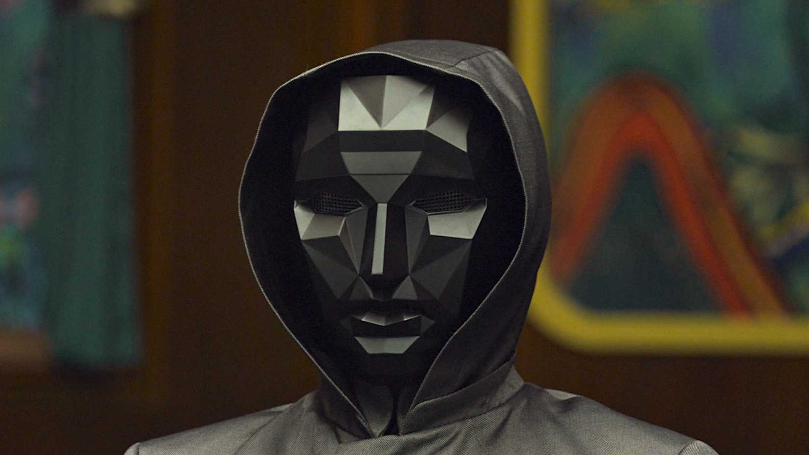 The Front Man in Squid Game wearing a geometric black mask.