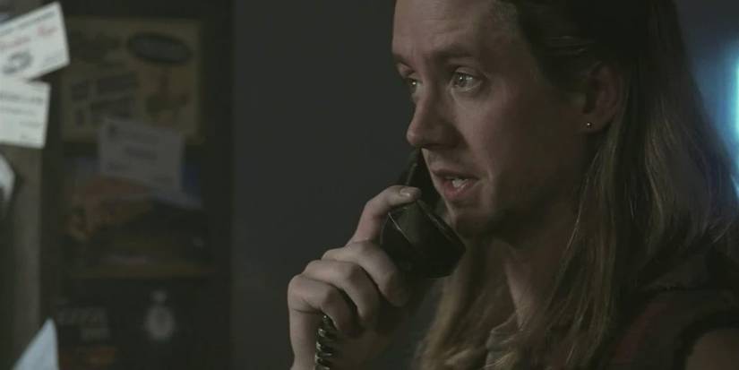 Still de Supernatural com Ash segurando um orelhão e falando.