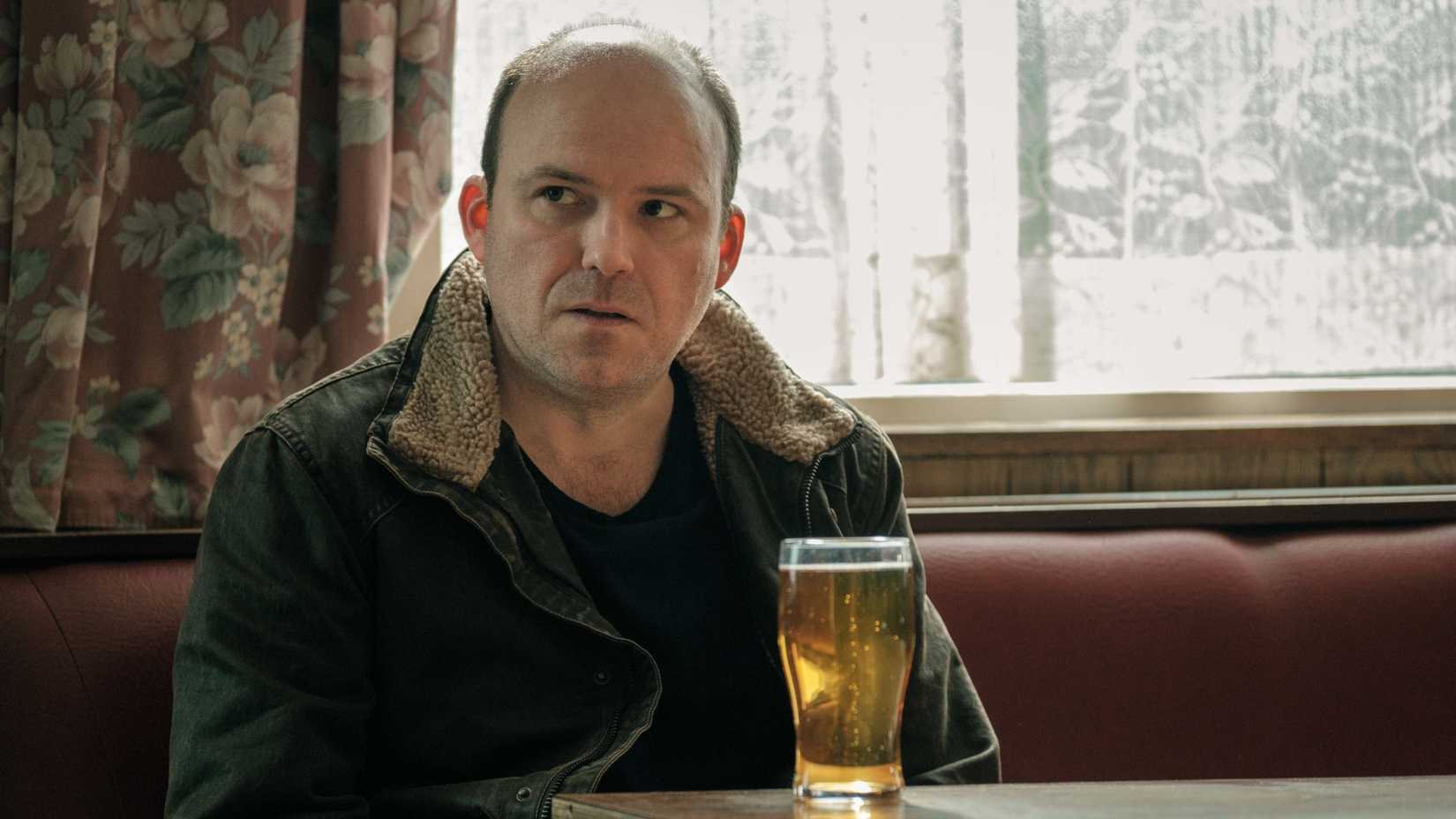 Rory Kinnear as Stephen Lyons sitting with a beer in a restaurant in Years and Years.