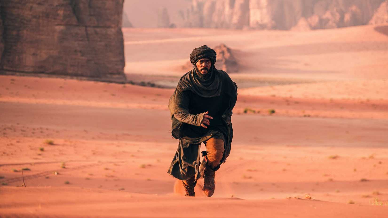 The bandit dressed all in black running in the desert in Desert Warrior